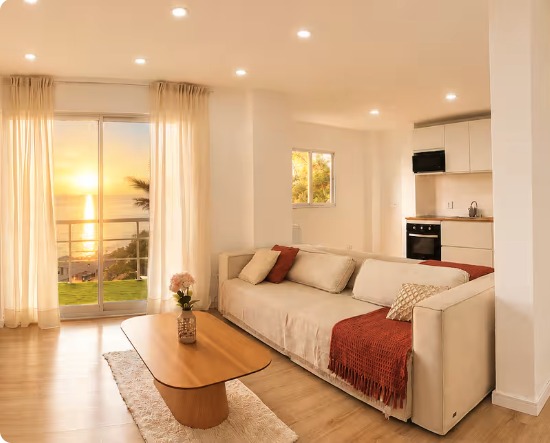 Salon lumineux de Casa Los Santos avec vue sur l'océan au coucher du soleil